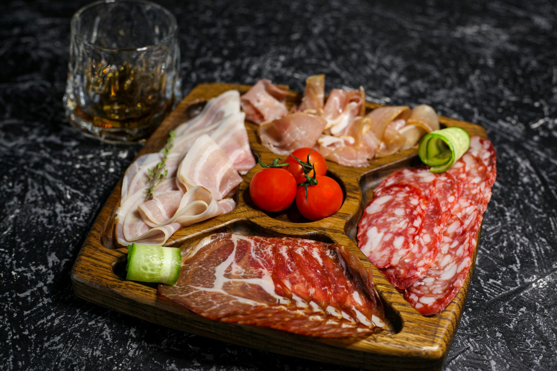 a wooden tray topped with meat and veggies